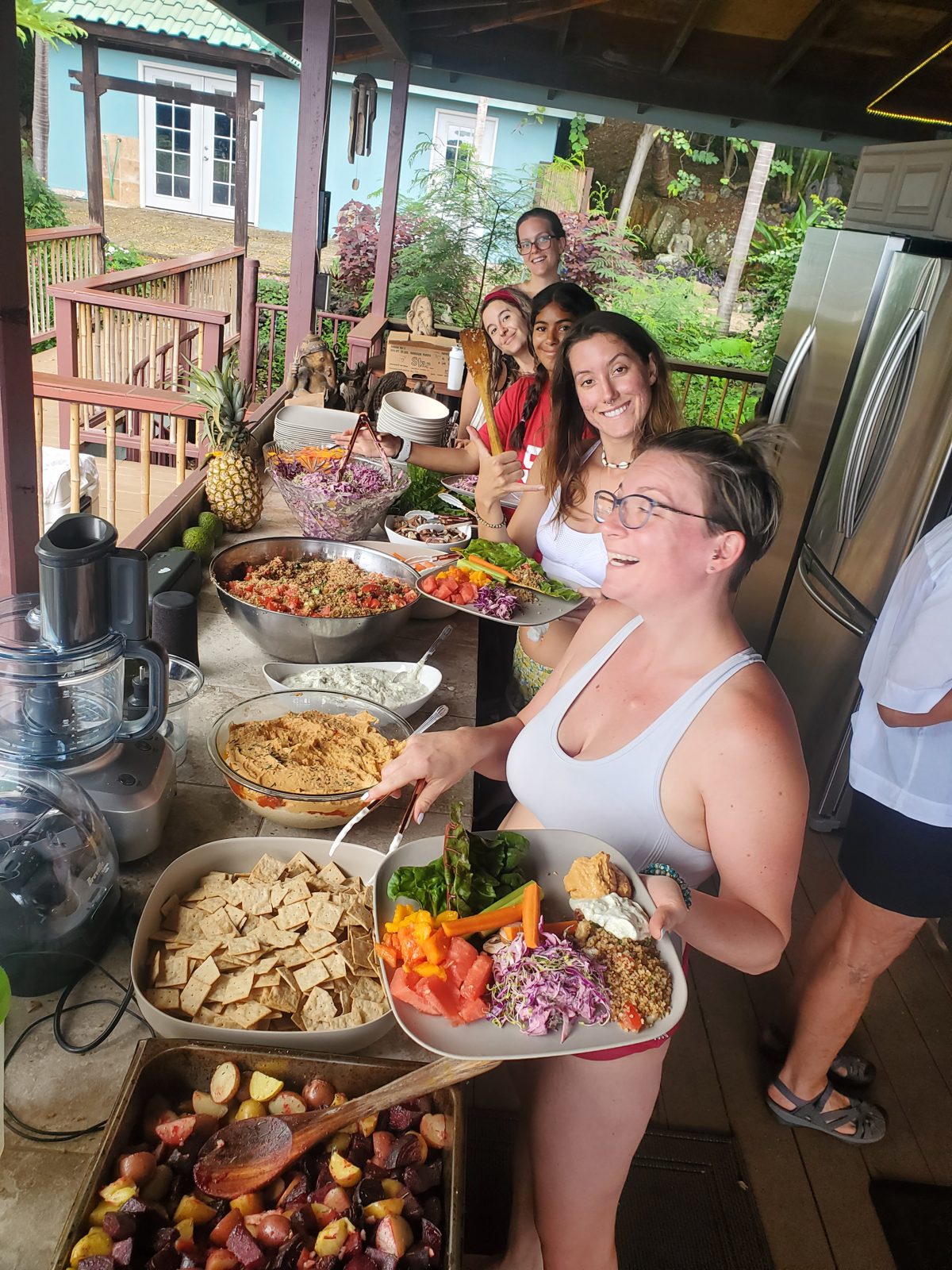 Smiling guests serving themselves from a colorful outdoor buffet