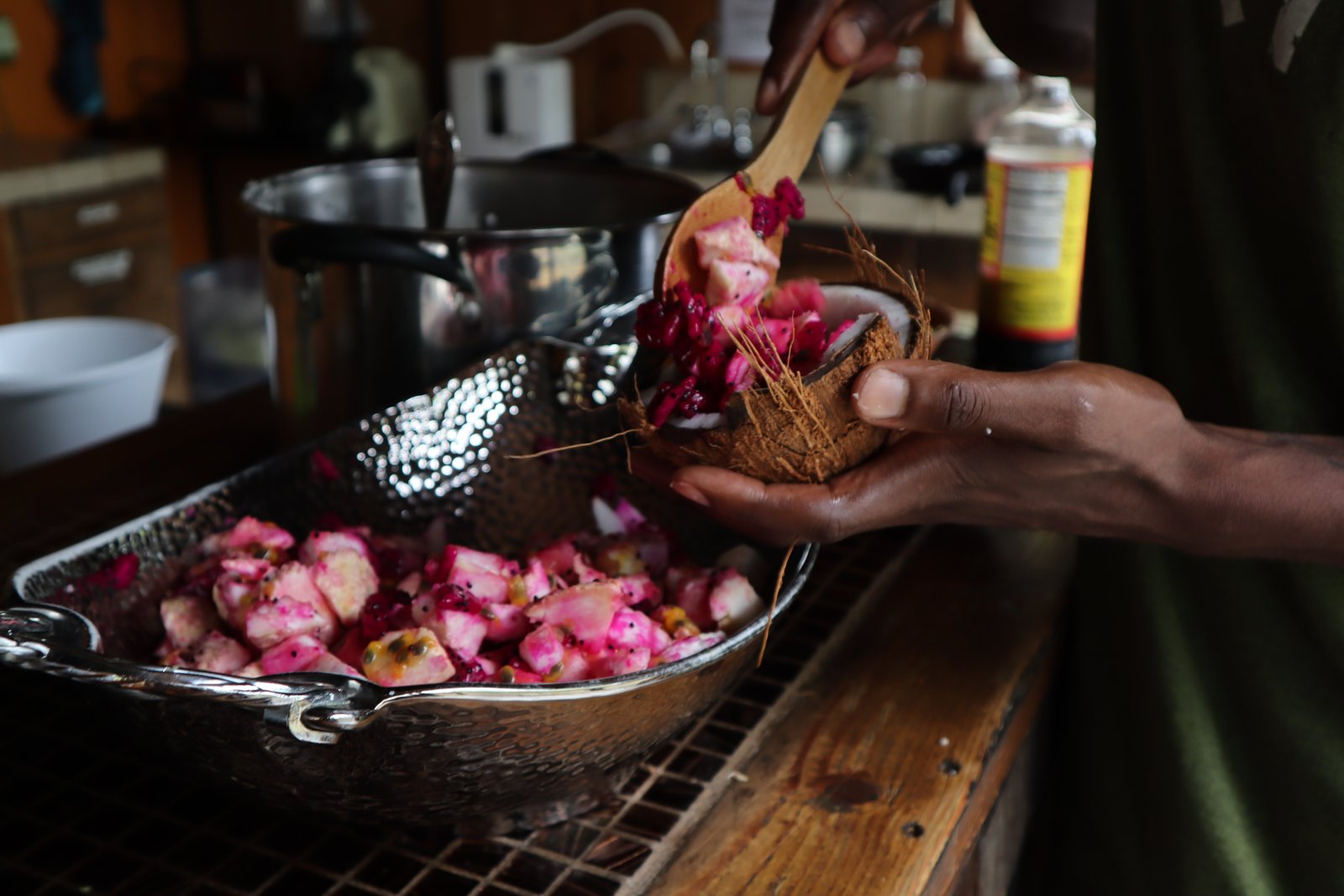 Spooning a bright pink dish from a pan into a coconut-shell bowl