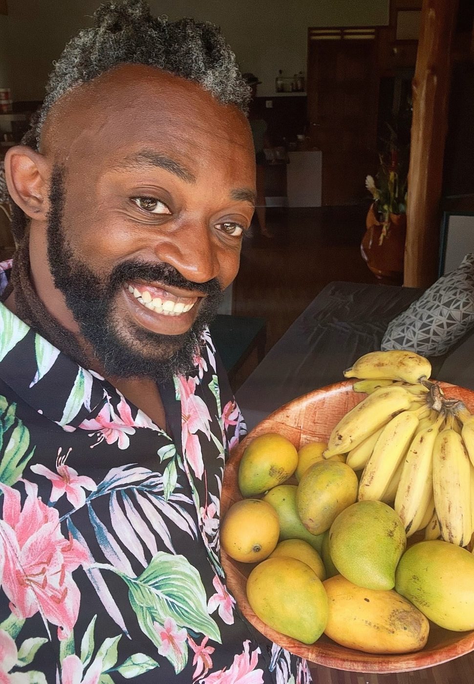 Terry Ford smiling with a bowl of mangoes and bananas